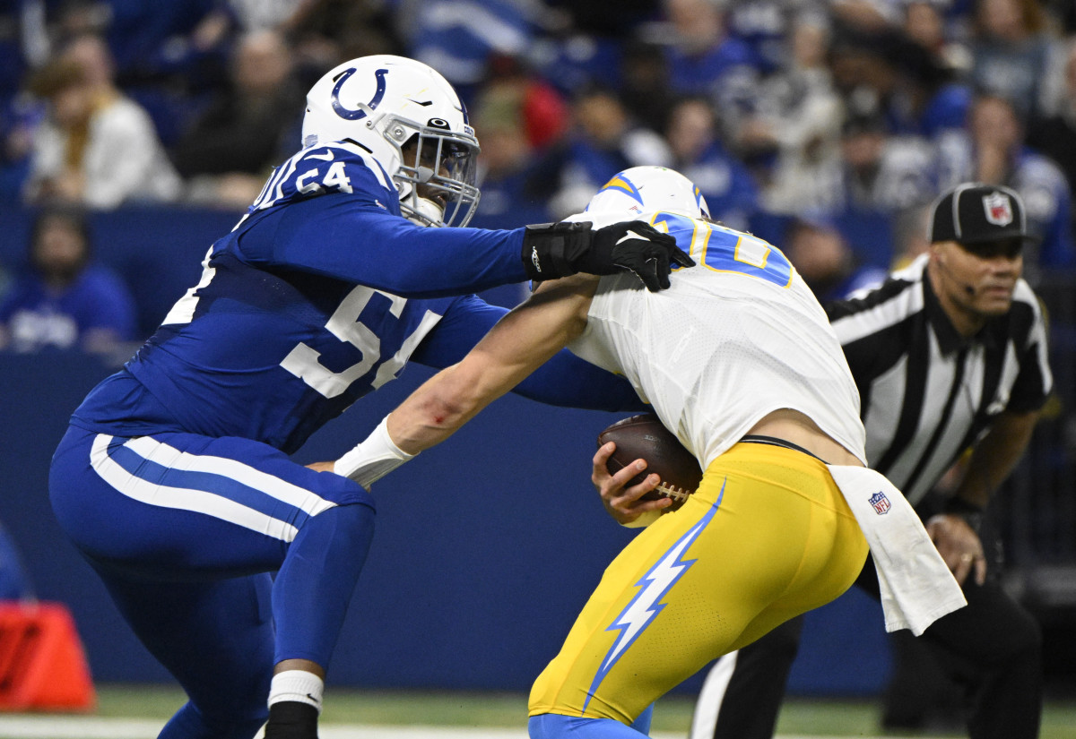 Dec 26, 2022; Indianapolis, Indiana, USA; Los Angeles Chargers quarterback Justin Herbert (10) is sacked by Indianapolis Colts defensive end Dayo Odeyingbo (54) during the second quarter at Lucas Oil Stadium.